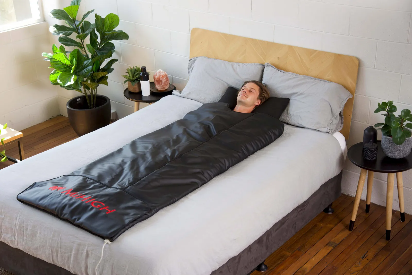 A person laying on the bed with a blanket