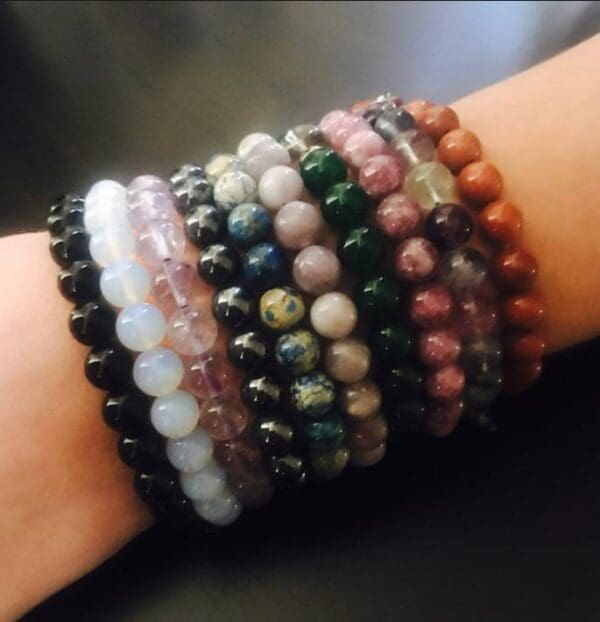 A wrist adorned with multiple colorful beaded jewelry.